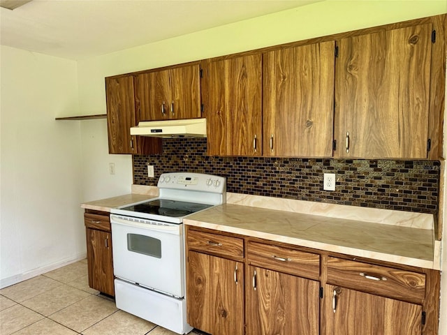 kitchen with brown cabinetry, backsplash, under cabinet range hood, and white range with electric cooktop