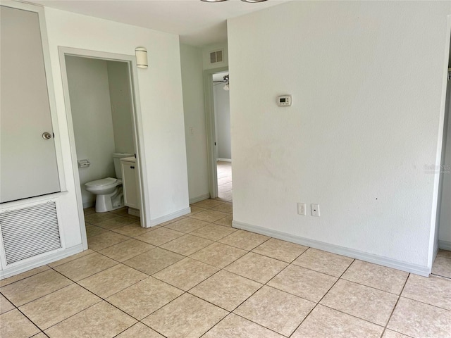 unfurnished bedroom with visible vents, baseboards, and light tile patterned floors