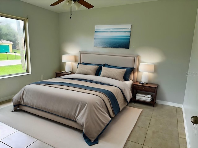 tiled bedroom with a ceiling fan and baseboards