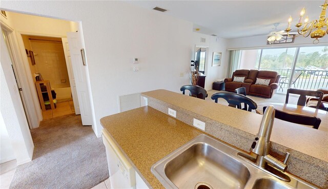 kitchen featuring light carpet, sink, and ceiling fan