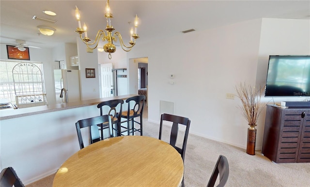 dining room featuring light carpet and ceiling fan with notable chandelier