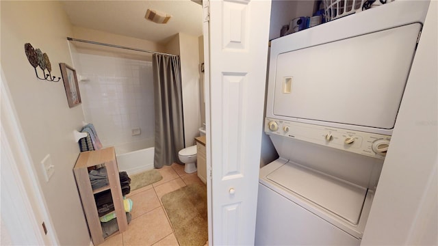 clothes washing area with stacked washing maching and dryer and light tile patterned floors