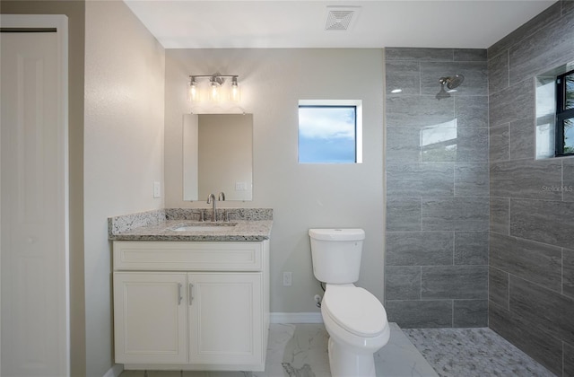 bathroom with marble finish floor, visible vents, toilet, vanity, and tiled shower