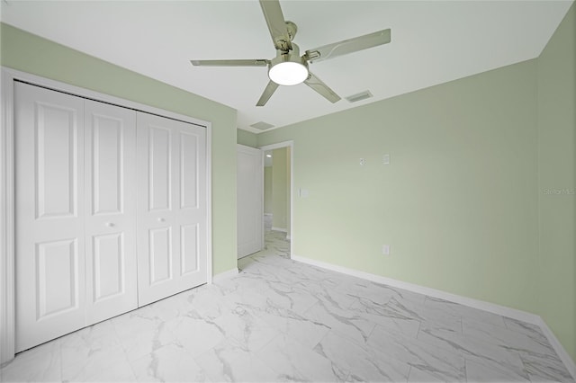 unfurnished bedroom with marble finish floor, a closet, visible vents, ceiling fan, and baseboards