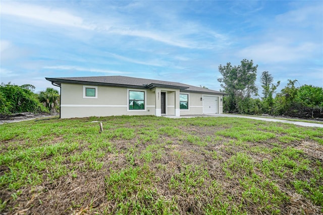 view of front of property with a garage, a front lawn, and stucco siding