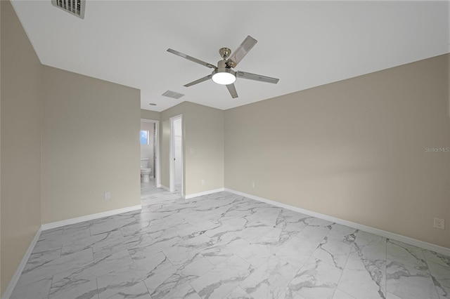 spare room with marble finish floor, visible vents, and baseboards