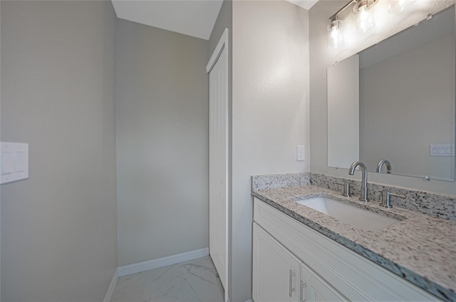 bathroom with marble finish floor, baseboards, and vanity