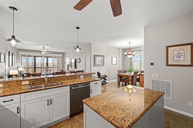 kitchen with white cabinets, a healthy amount of sunlight, sink, a center island with sink, and dishwasher