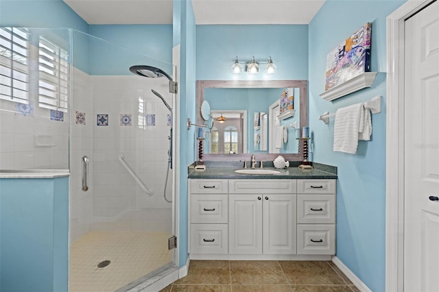 bathroom featuring tile patterned flooring, vanity, plenty of natural light, and a shower with shower door