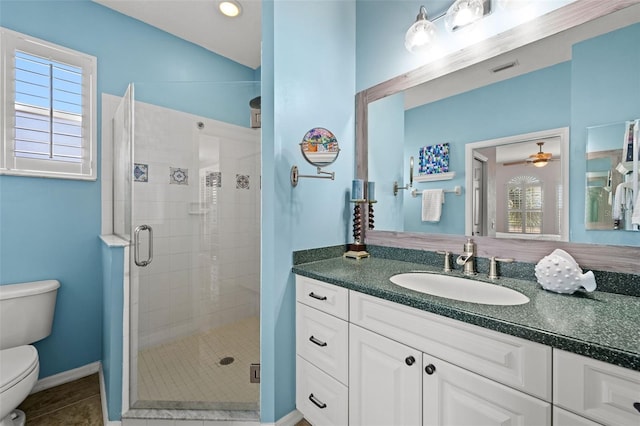 bathroom with vanity, toilet, ceiling fan, and a shower with shower door