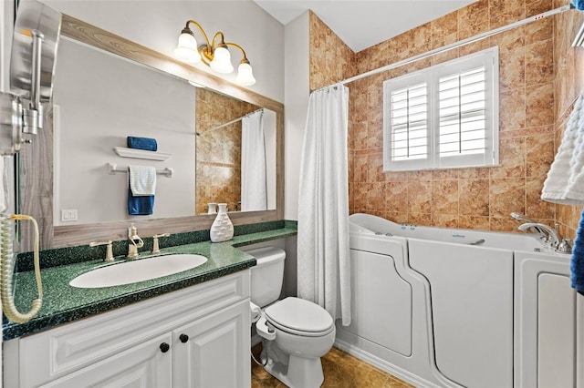 bathroom featuring vanity, tile walls, and toilet