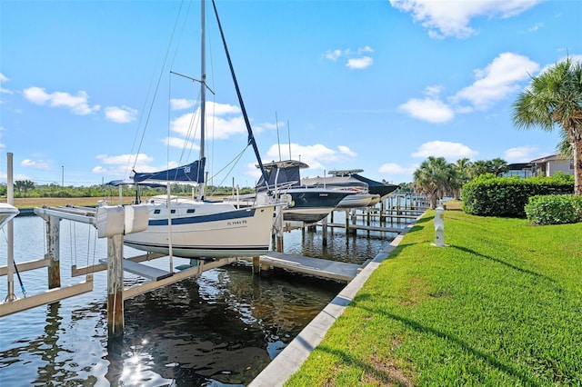 view of dock with a lawn and a water view