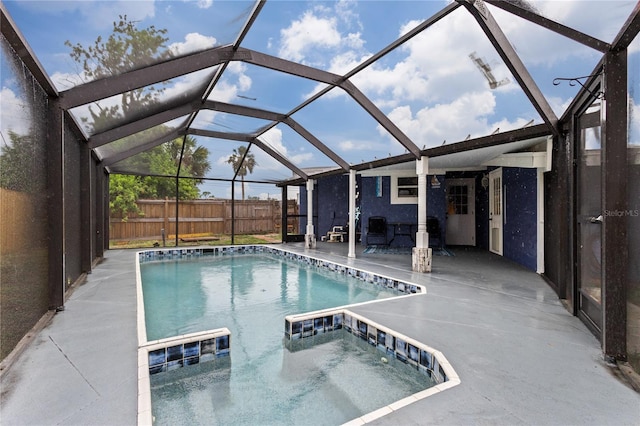 view of pool featuring glass enclosure and a patio area