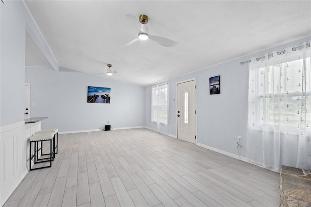 foyer entrance with ceiling fan and light hardwood / wood-style flooring