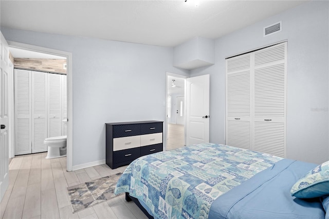 bedroom featuring light hardwood / wood-style floors, a closet, and ensuite bath