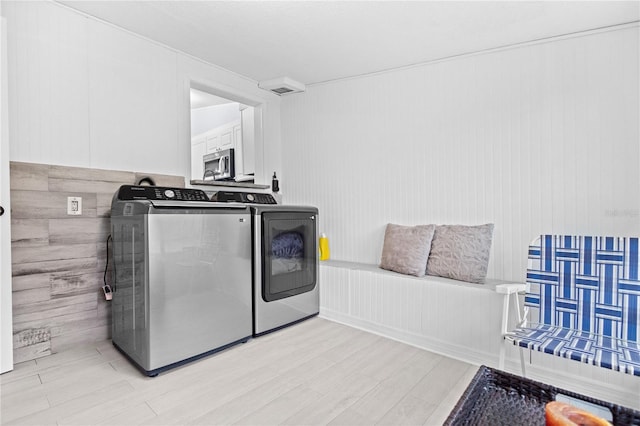 washroom with light hardwood / wood-style floors and washing machine and clothes dryer