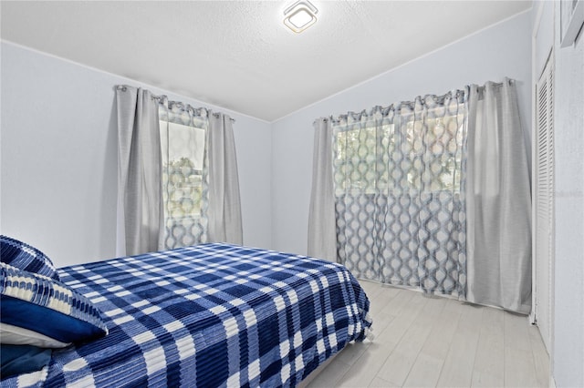 bedroom with hardwood / wood-style floors and a textured ceiling