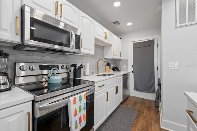 kitchen featuring appliances with stainless steel finishes, decorative backsplash, dark hardwood / wood-style floors, sink, and white cabinetry