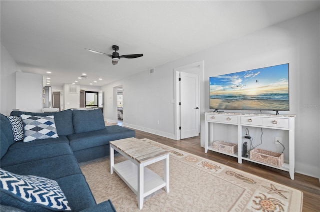 living room featuring hardwood / wood-style floors and ceiling fan