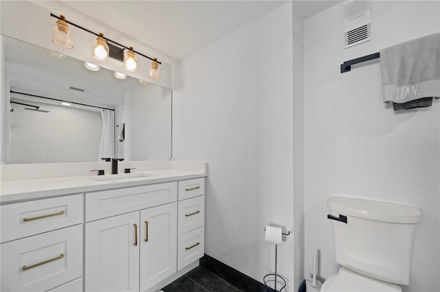 bathroom with a textured ceiling, toilet, walk in shower, tile patterned floors, and vanity