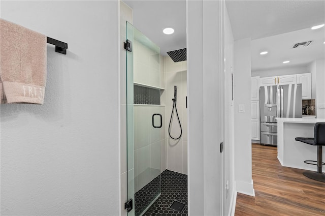 bathroom featuring an enclosed shower and hardwood / wood-style floors