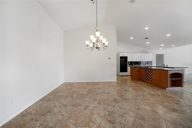 kitchen with hanging light fixtures, vaulted ceiling, decorative backsplash, kitchen peninsula, and a chandelier