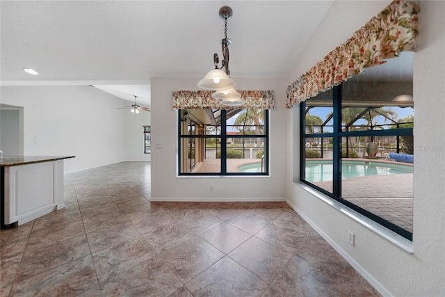 unfurnished dining area with ceiling fan and vaulted ceiling