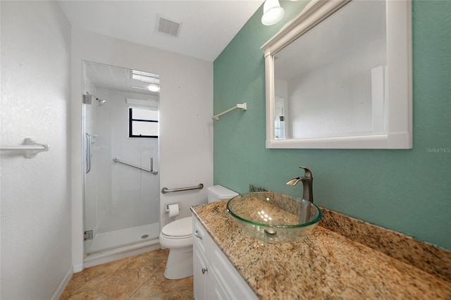 bathroom featuring tile patterned flooring, vanity, toilet, and a shower with door