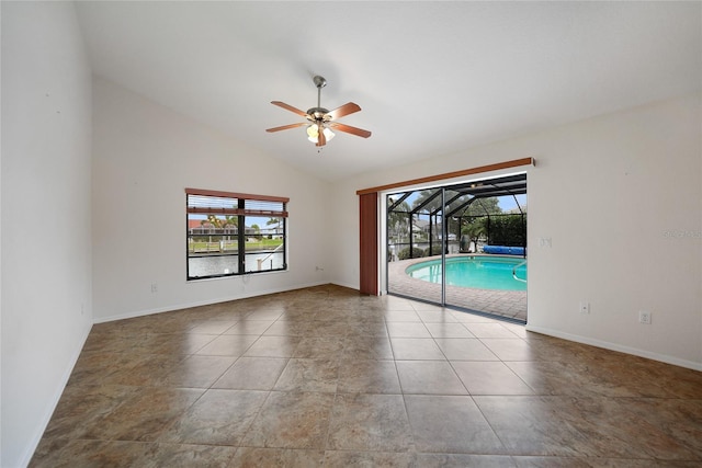 tiled empty room with vaulted ceiling and ceiling fan