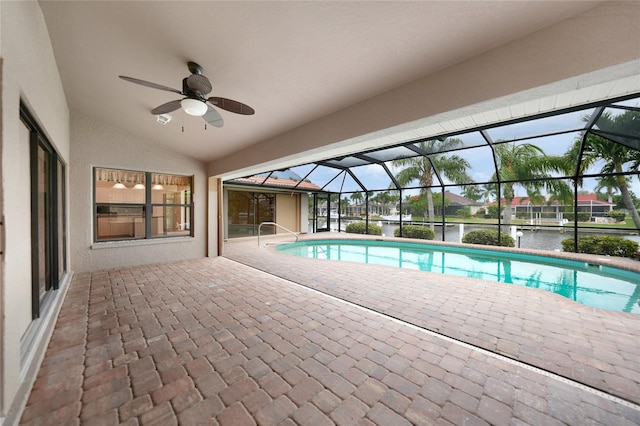 view of pool featuring ceiling fan, a patio area, a water view, and glass enclosure