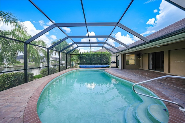 view of pool featuring a patio area, a lanai, and a water view