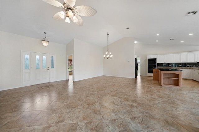 kitchen with white cabinets, ceiling fan with notable chandelier, black fridge, decorative backsplash, and decorative light fixtures