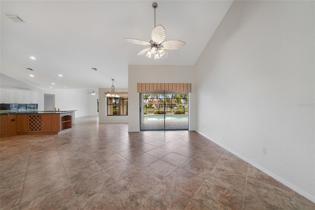 unfurnished living room featuring ceiling fan, lofted ceiling, and sink