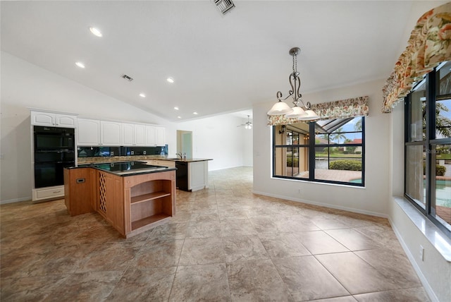 kitchen with ceiling fan, white cabinets, a kitchen island, hanging light fixtures, and lofted ceiling