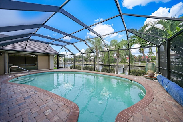 view of pool with a water view, glass enclosure, and a patio area