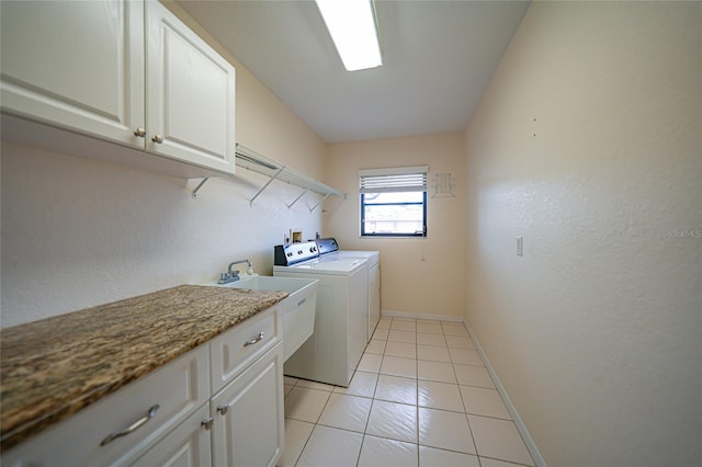 laundry area featuring washer and dryer, light tile patterned floors, cabinets, and sink