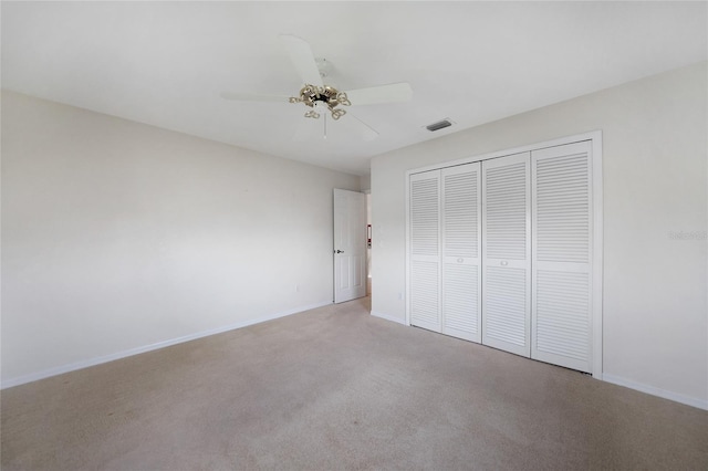 unfurnished bedroom featuring a closet, ceiling fan, and light colored carpet