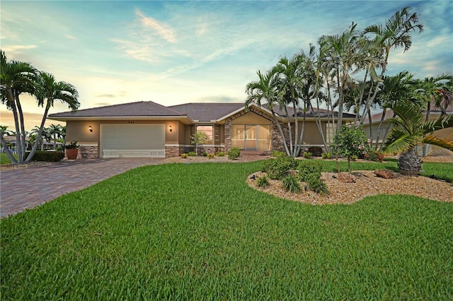 view of front of home with a yard and a garage