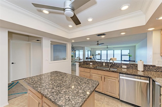 kitchen featuring light brown cabinets, sink, stainless steel dishwasher, dark stone countertops, and a kitchen island