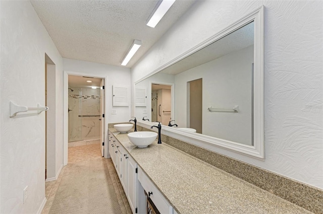 bathroom featuring vanity, a shower, and a textured ceiling