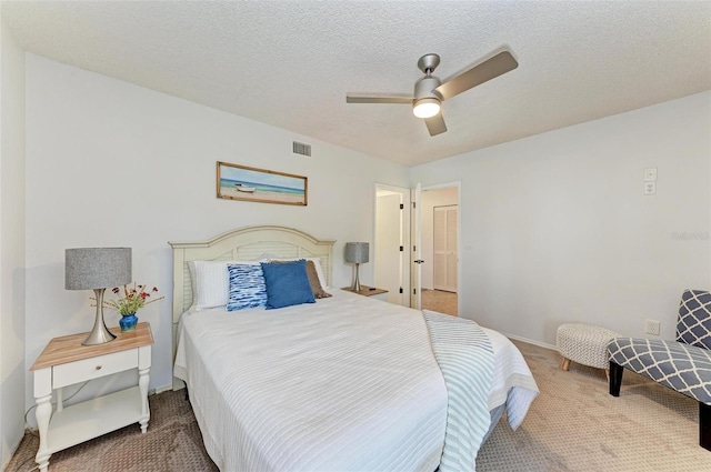 carpeted bedroom with ceiling fan and a textured ceiling