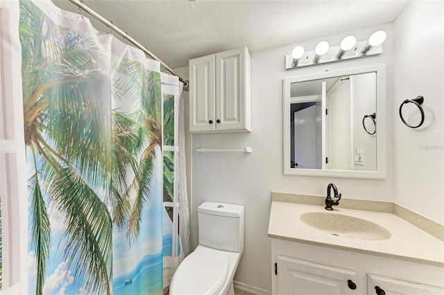 bathroom featuring vanity, a textured ceiling, and toilet