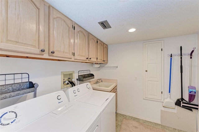 laundry area featuring washing machine and clothes dryer, sink, cabinets, a textured ceiling, and light tile patterned flooring