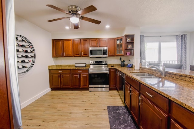 kitchen featuring light stone countertops, sink, stainless steel appliances, and light hardwood / wood-style flooring