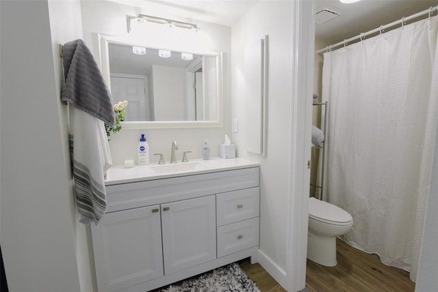 bathroom featuring toilet, vanity, and hardwood / wood-style flooring