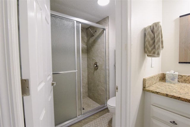 bathroom featuring vanity, toilet, and a shower with door