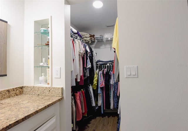 walk in closet with dark hardwood / wood-style flooring