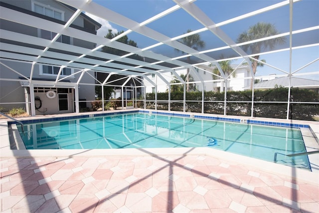 view of pool with glass enclosure and a patio area