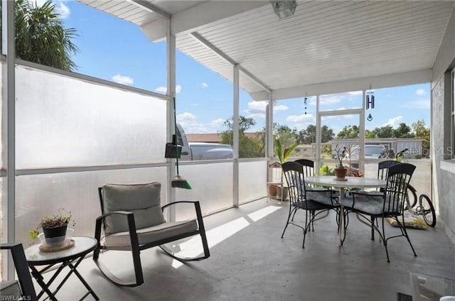 sunroom / solarium featuring beamed ceiling