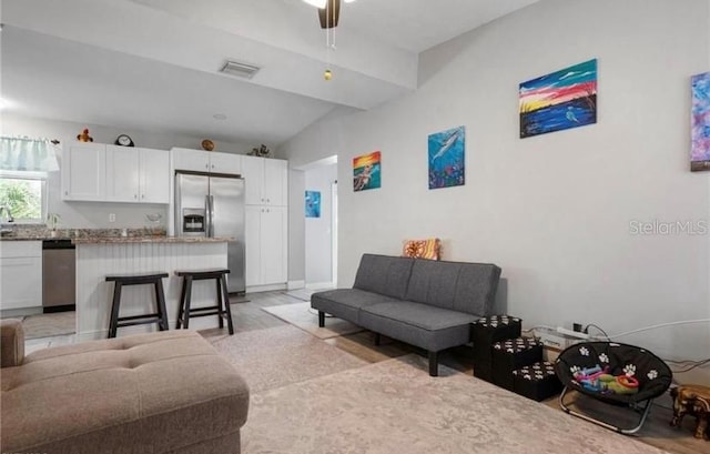 living room with light wood-type flooring, vaulted ceiling, and ceiling fan